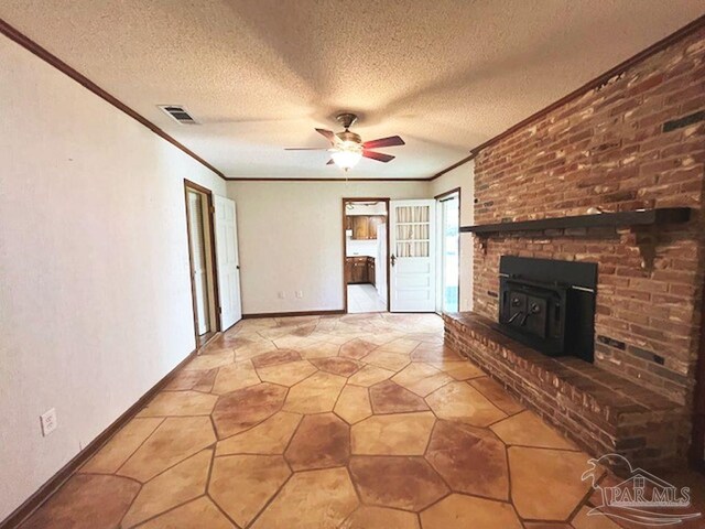 unfurnished living room with a fireplace, a textured ceiling, light tile patterned flooring, and a wood stove