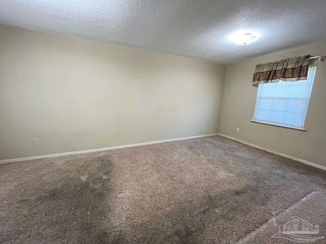 unfurnished room with a textured ceiling and carpet floors