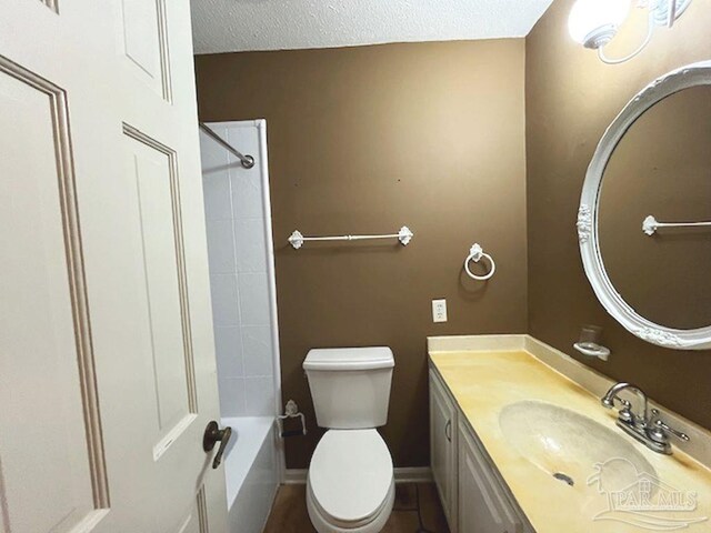 full bathroom featuring a textured ceiling, bathtub / shower combination, vanity, and toilet