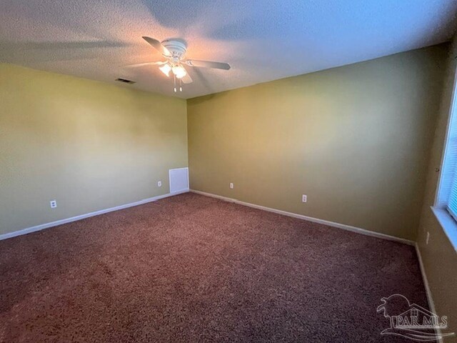 carpeted empty room featuring ceiling fan and a textured ceiling