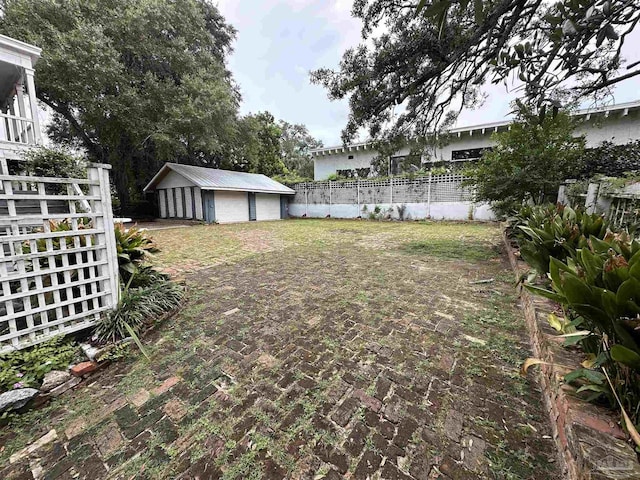 view of yard featuring a garage and an outbuilding