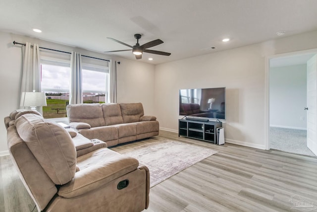 living room featuring light wood-type flooring, baseboards, and recessed lighting