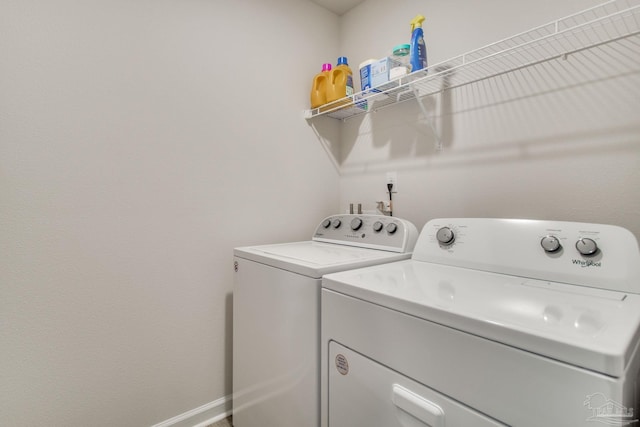 laundry room featuring laundry area, washing machine and clothes dryer, and baseboards