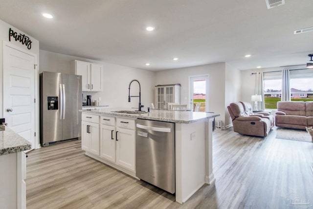 kitchen with a sink, visible vents, a healthy amount of sunlight, appliances with stainless steel finishes, and light wood finished floors