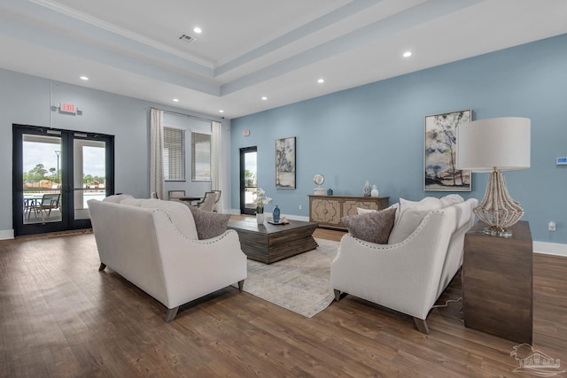 living room with wood-type flooring, french doors, and a tray ceiling