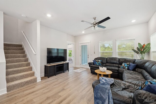 living room with light hardwood / wood-style flooring and ceiling fan