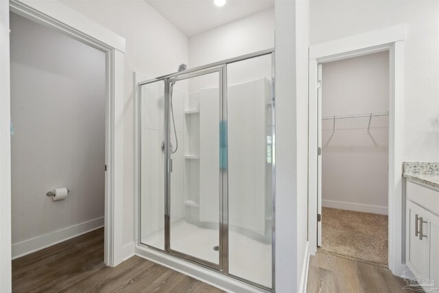 bathroom featuring vanity, an enclosed shower, and hardwood / wood-style floors