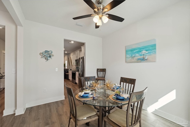 dining space with hardwood / wood-style flooring and ceiling fan