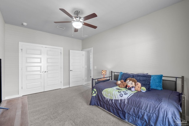 bedroom featuring carpet flooring, visible vents, baseboards, a ceiling fan, and a closet