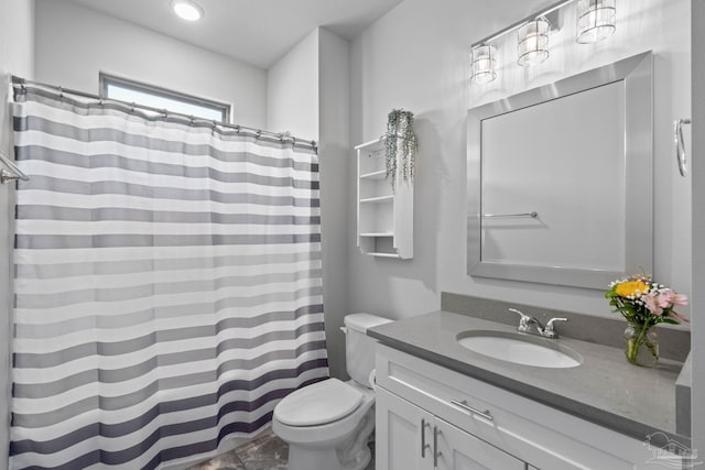 bathroom featuring curtained shower, vanity, and toilet