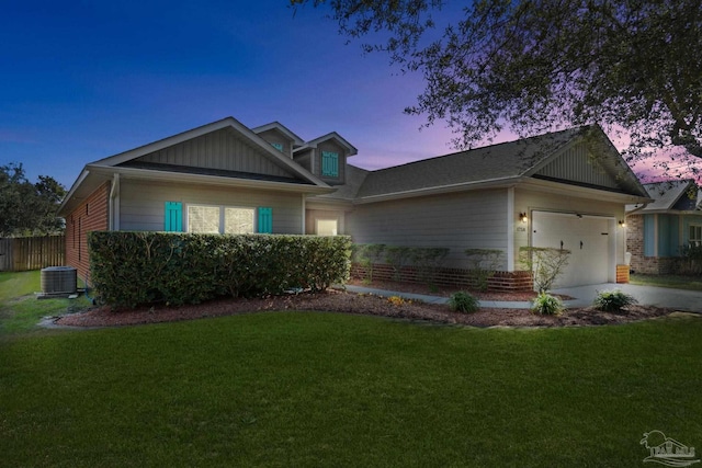 view of front of property with an attached garage, a front lawn, cooling unit, and concrete driveway