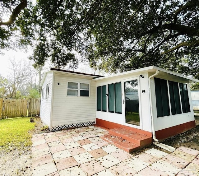 rear view of house featuring a patio and a sunroom