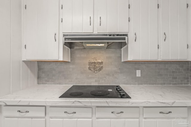 kitchen with white cabinetry, under cabinet range hood, black electric cooktop, and backsplash