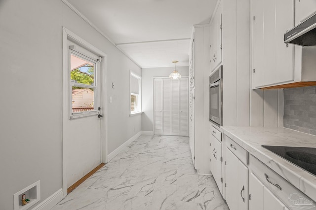 kitchen with under cabinet range hood, marble finish floor, and white cabinetry