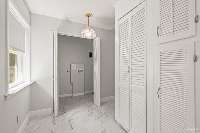 interior space featuring crown molding, baseboards, and marble finish floor