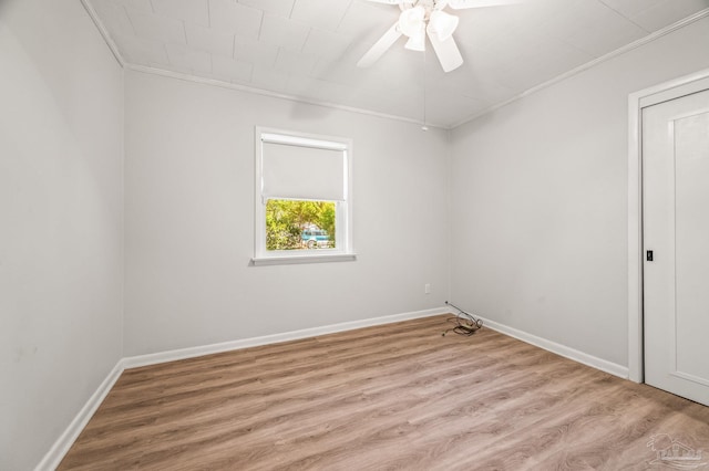 spare room featuring baseboards, ornamental molding, a ceiling fan, and wood finished floors