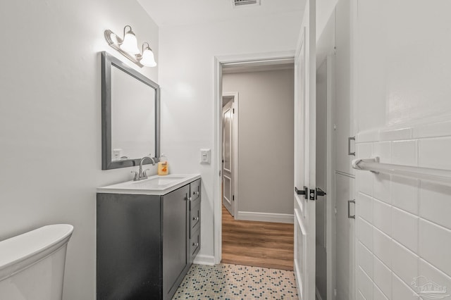 bathroom with visible vents, toilet, vanity, and tile patterned floors