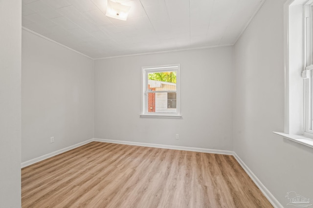 unfurnished room with light wood finished floors, baseboards, and ornamental molding