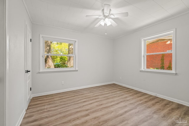 unfurnished room featuring crown molding, light wood-style flooring, a ceiling fan, and baseboards