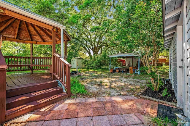 view of yard with a storage shed, an outdoor structure, a patio, a gazebo, and a deck