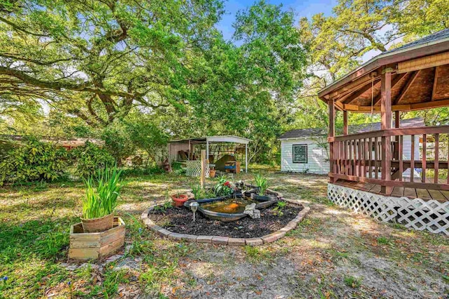 view of yard featuring a deck, a storage shed, and an outdoor structure