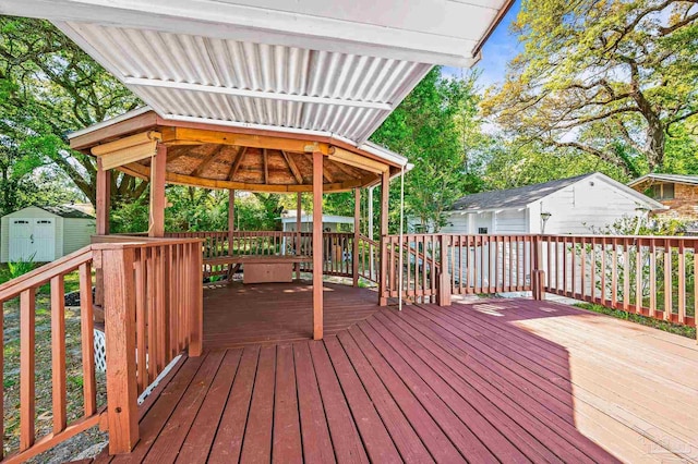 wooden deck with a shed, a gazebo, and an outdoor structure