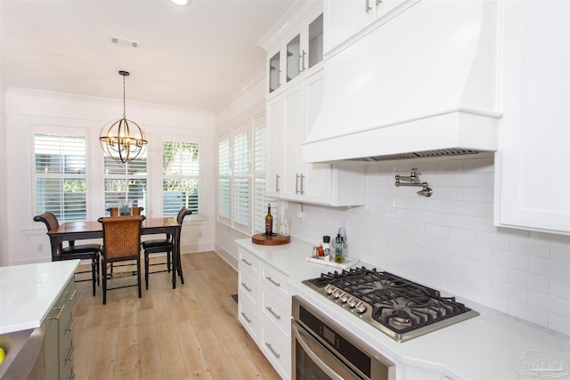 kitchen with visible vents, stainless steel appliances, crown molding, and premium range hood