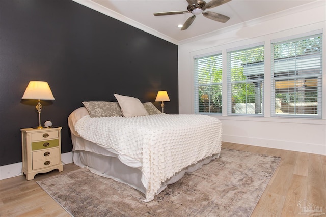 bedroom with baseboards, recessed lighting, an accent wall, crown molding, and light wood-type flooring