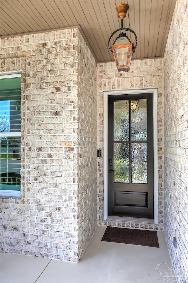 doorway to property featuring brick siding