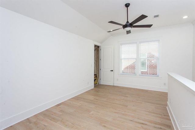 spare room featuring visible vents, light wood finished floors, baseboards, ceiling fan, and vaulted ceiling