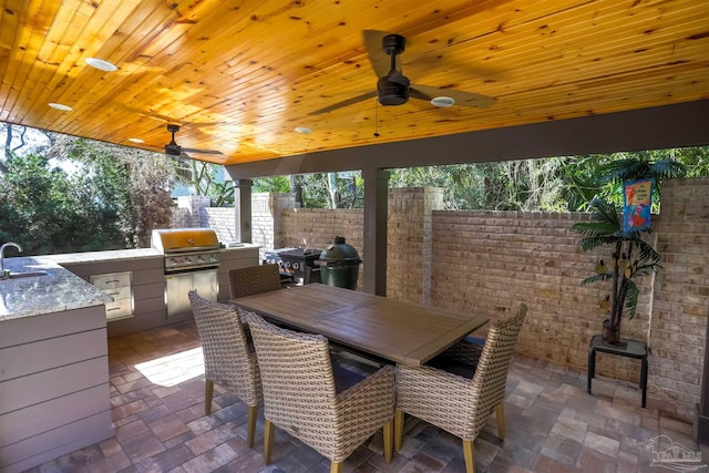 view of patio / terrace featuring ceiling fan, fence, outdoor dining space, area for grilling, and a sink