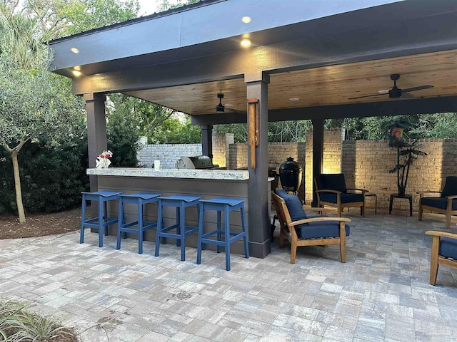 view of patio / terrace featuring a ceiling fan, grilling area, fence, and outdoor dry bar