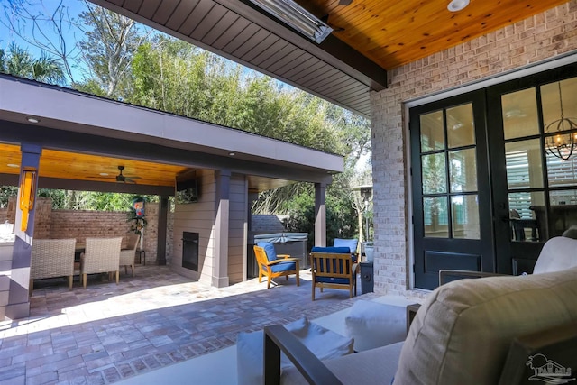 view of patio with outdoor dining space, an outdoor living space, a ceiling fan, and a hot tub