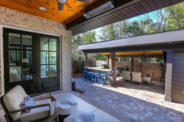 view of patio / terrace with ceiling fan, outdoor dining area, outdoor dry bar, and fence