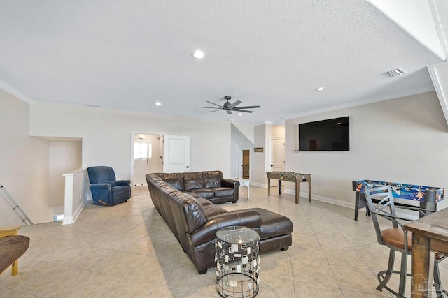 tiled living room featuring ceiling fan, a textured ceiling, and crown molding