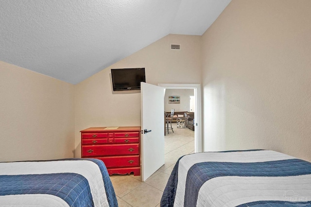 tiled bedroom with a textured ceiling and vaulted ceiling