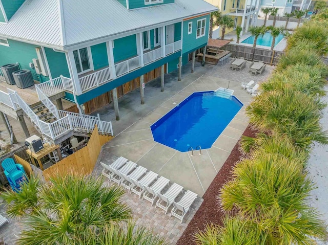 view of swimming pool with cooling unit and a patio