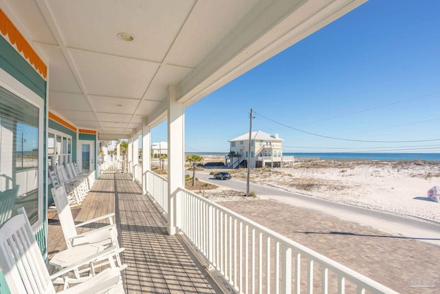 balcony featuring a beach view and a water view