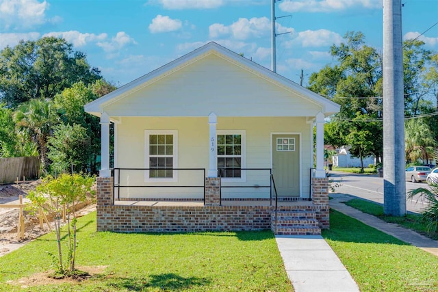 bungalow-style home with a front lawn and covered porch