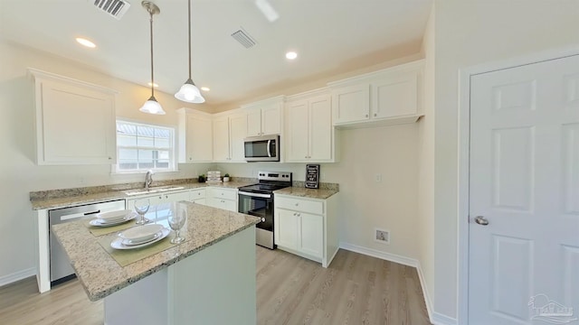 kitchen with white cabinets, stainless steel appliances, and a kitchen island