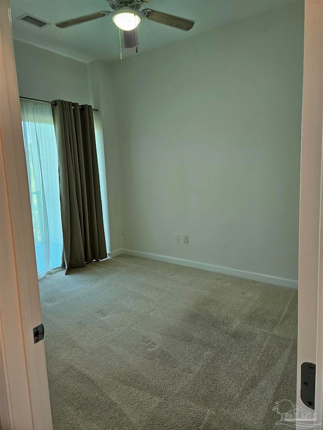 spare room with ceiling fan and light colored carpet