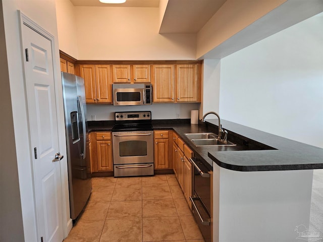 kitchen featuring stainless steel appliances, kitchen peninsula, light tile patterned floors, and sink