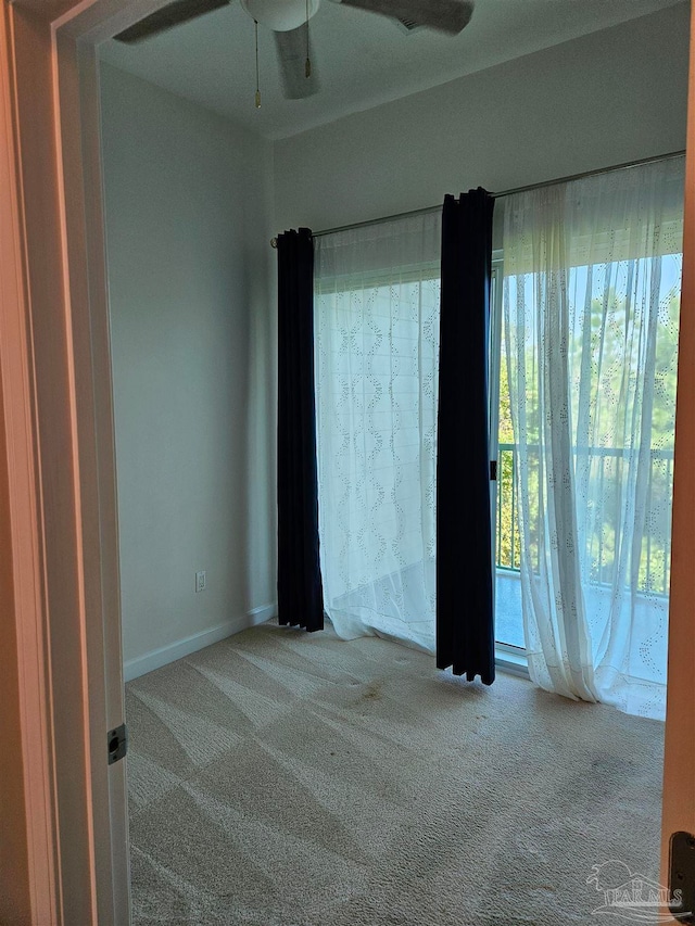 carpeted empty room with ceiling fan and a healthy amount of sunlight