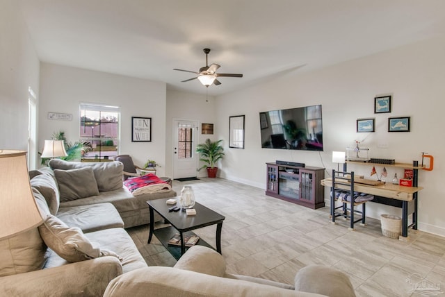 living room with baseboards and a ceiling fan