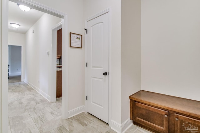 hall featuring baseboards