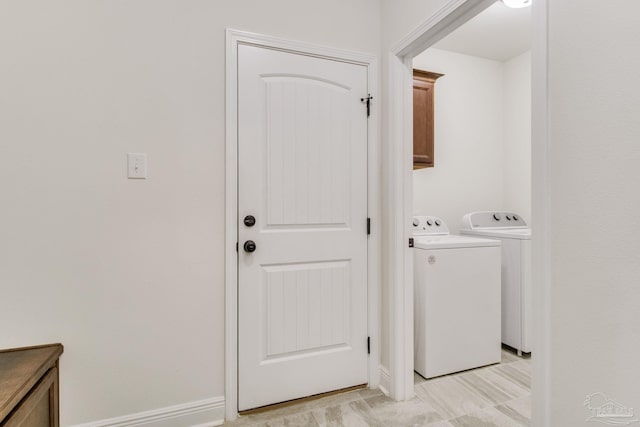 laundry area with baseboards and washer and dryer