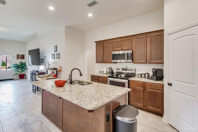 kitchen featuring recessed lighting, visible vents, appliances with stainless steel finishes, a sink, and light stone countertops