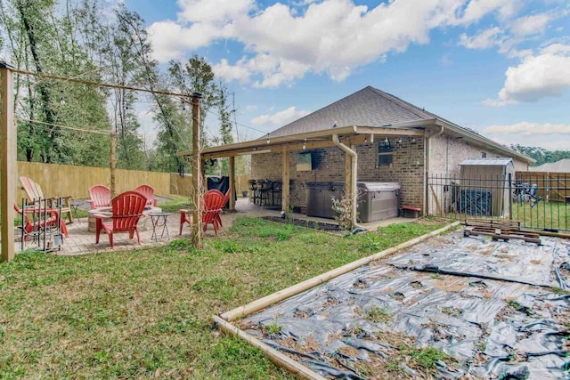 view of yard with an outdoor fire pit, a fenced backyard, a patio, and a hot tub