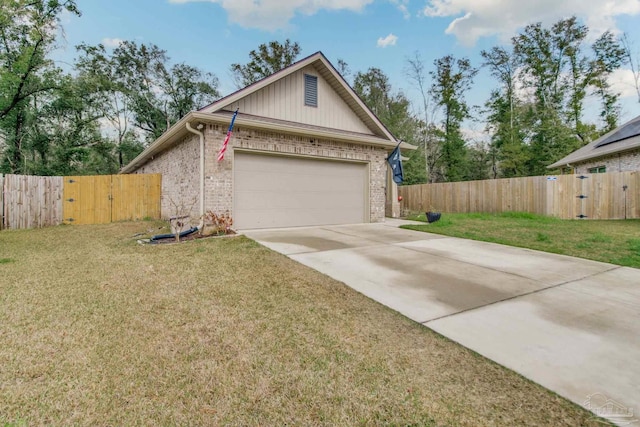 view of front of home with a front yard, a gate, brick siding, and driveway