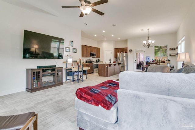 living area with recessed lighting, visible vents, baseboards, and ceiling fan with notable chandelier